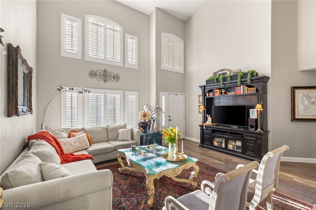3950 Candleglow Court, Las Vegas, NV 89147 Double-height ceilings and tall shuttered windows create an airy atmosphere in this central living area.