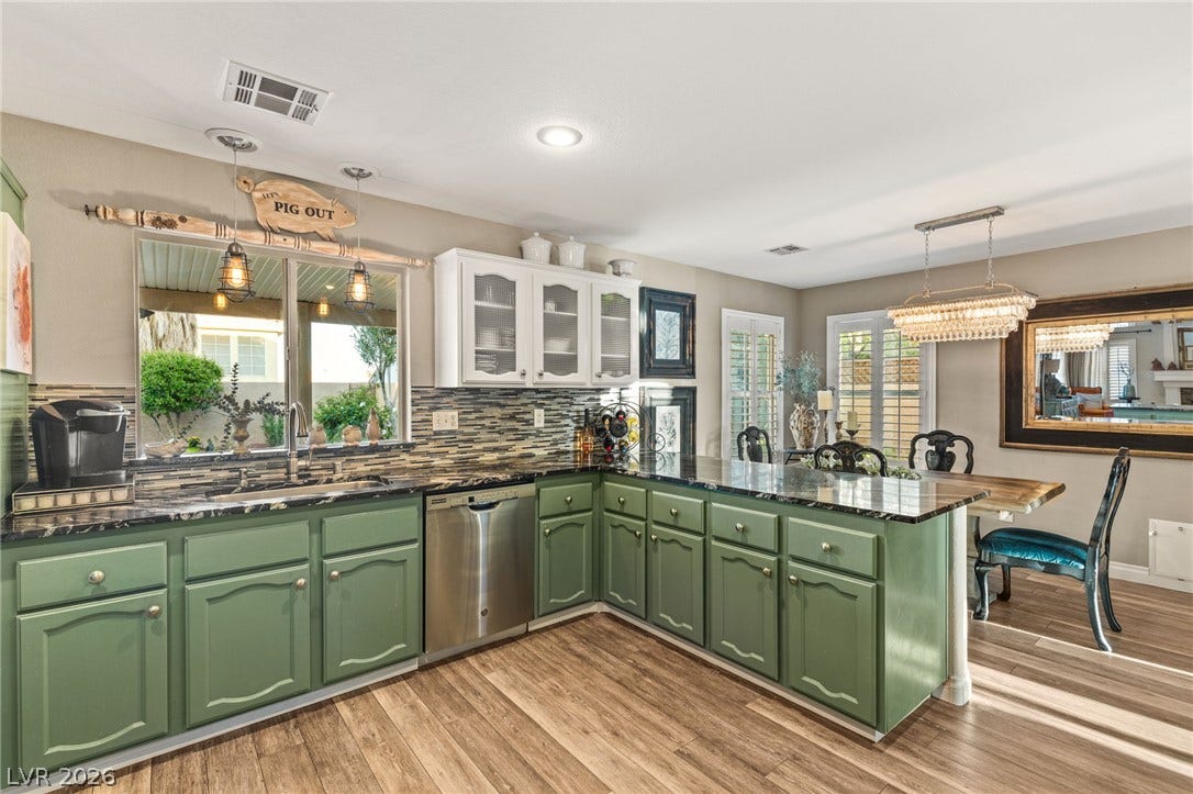 3950 Candleglow Court, Las Vegas, NV 89147 Gleaming stone countertops and warm wood floors anchor this open-concept kitchen.