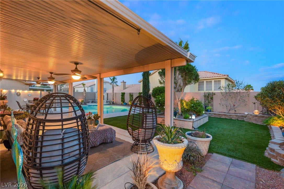 3950 Candleglow Court, Las Vegas, NV 89147 An inviting covered patio overlooks a manicured backyard with a sparkling swimming pool.