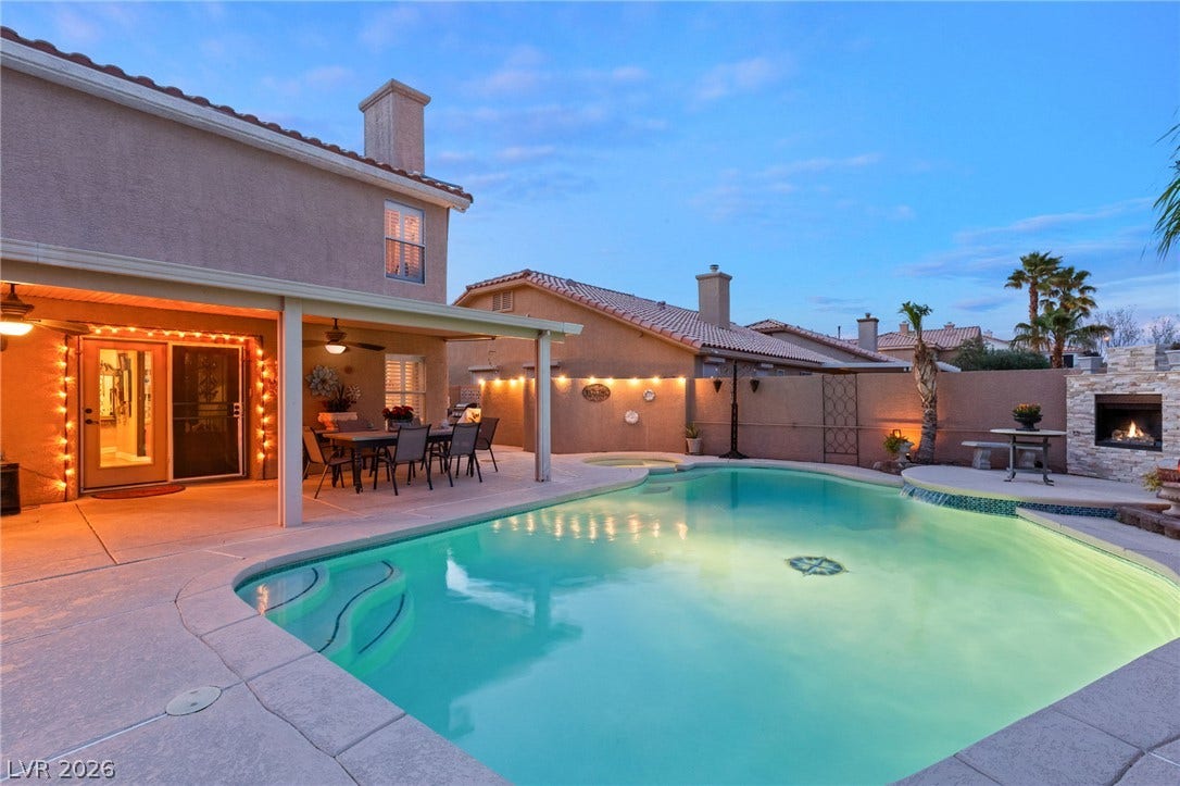 3950 Candleglow Court, Las Vegas, NV 89147 An inviting backyard oasis features a shimmering swimming pool alongside a covered dining patio.