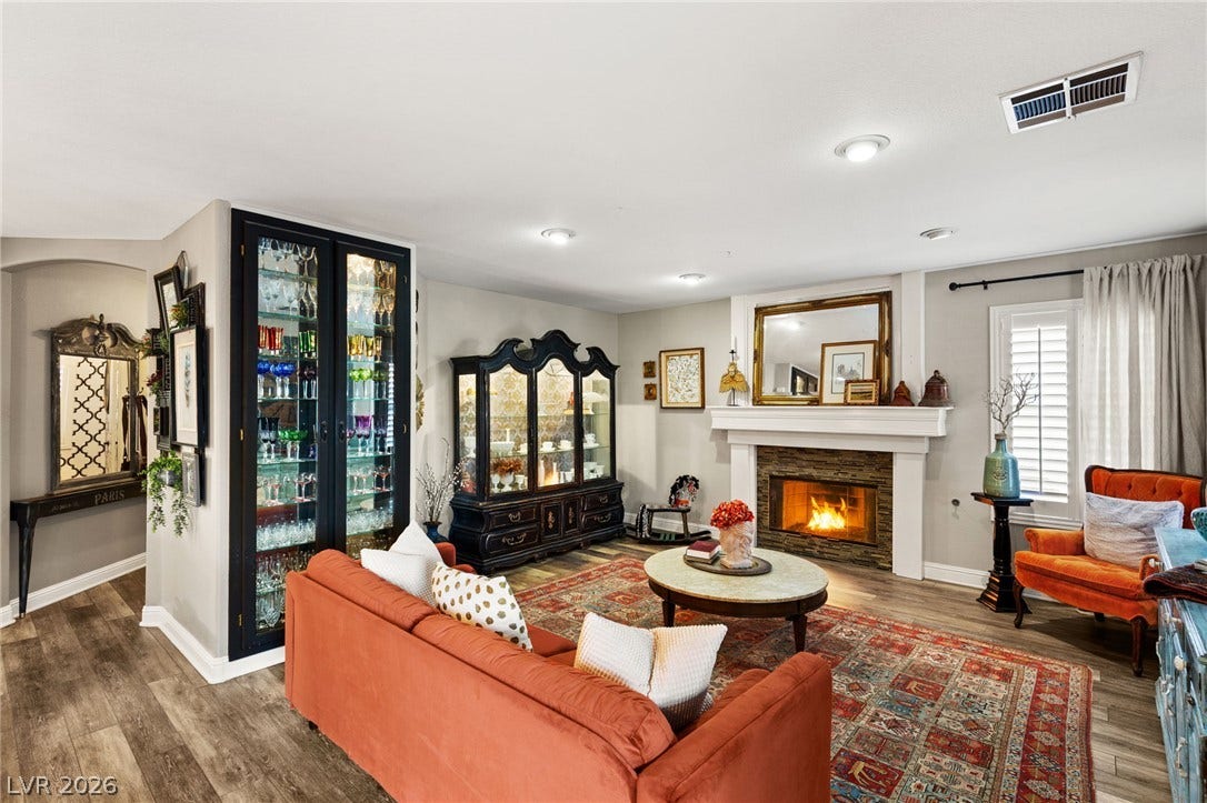 3950 Candleglow Court, Las Vegas, NV 89147 Rich wood flooring runs through this comfortable gathering space featuring a classic stone-surround fireplace.