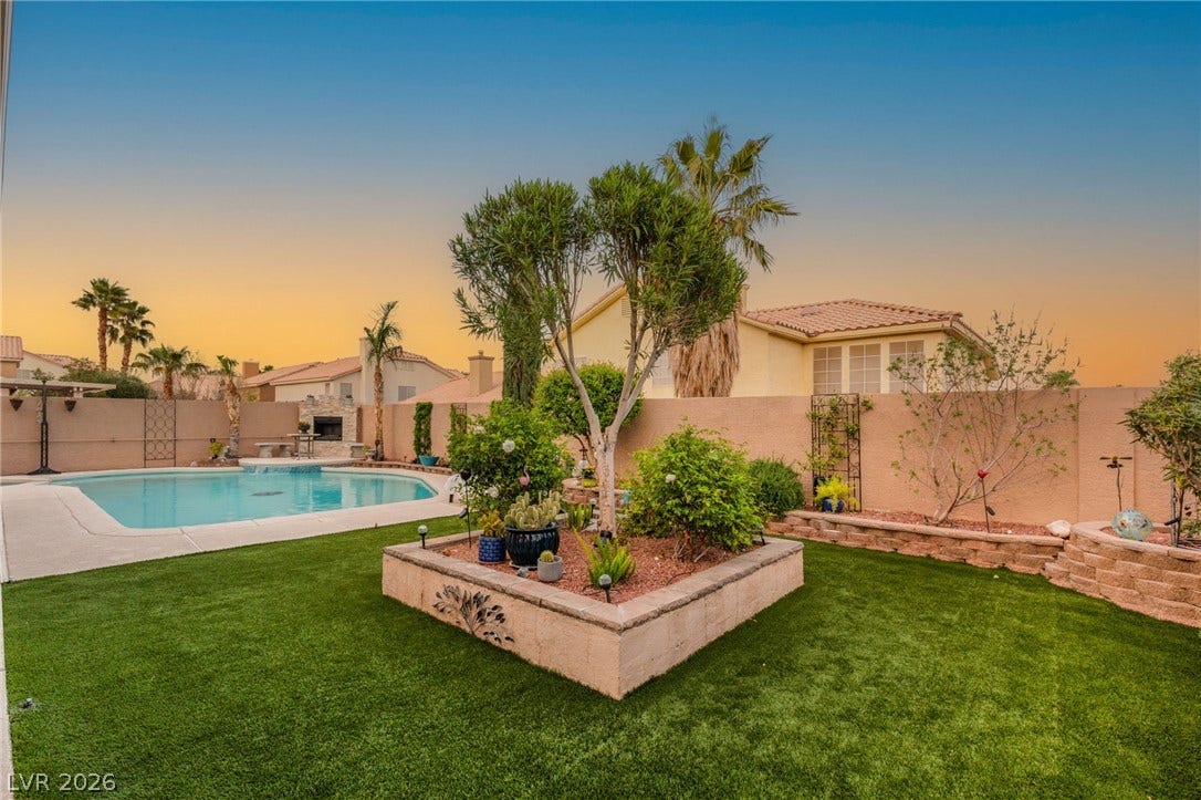 3950 Candleglow Court, Las Vegas, NV 89147 Lush green turf surrounds a sparkling swimming pool and beautifully landscaped raised stone garden beds.