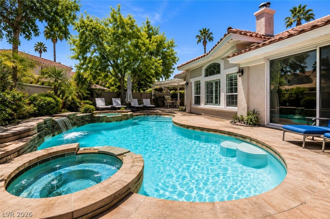 1892 Woodhaven Drive, Henderson, NV 89074 An inviting backyard oasis awaits with a sparkling pool and integrated spa, surrounded by lush landscaping and a spacious patio.