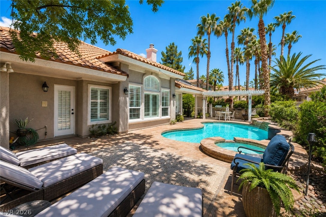 1892 Woodhaven Drive, Henderson, NV 89074 A private outdoor oasis awaits, featuring a refreshing pool, integrated spa, and an inviting pergola-covered dining area.