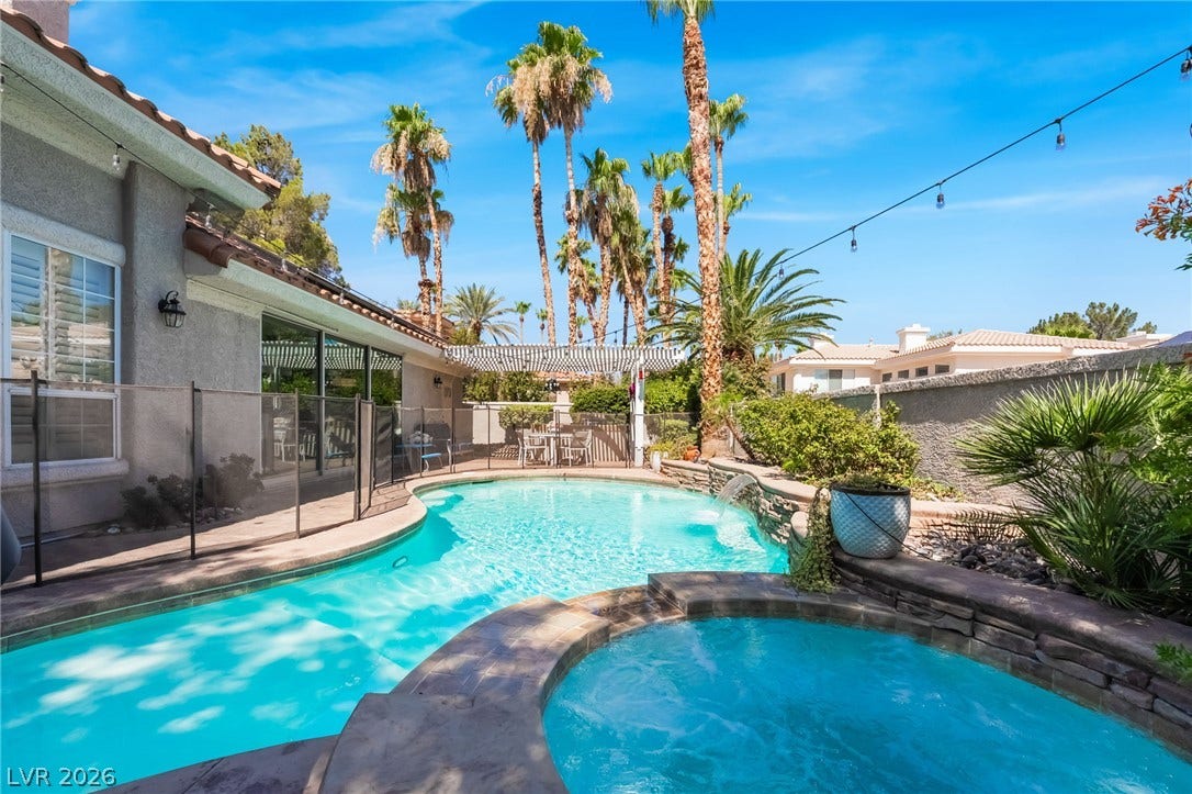 1892 Woodhaven Drive, Henderson, NV 89074 An inviting private pool and spa oasis awaits, surrounded by lush palms and a charming pergola. Removable safety fence.