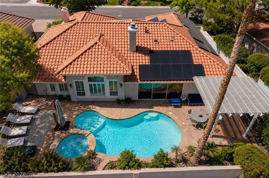 1892 Woodhaven Drive, Henderson, NV 89074 A terracotta-tiled roofed home offers a private backyard oasis with a sparkling pool and spa.