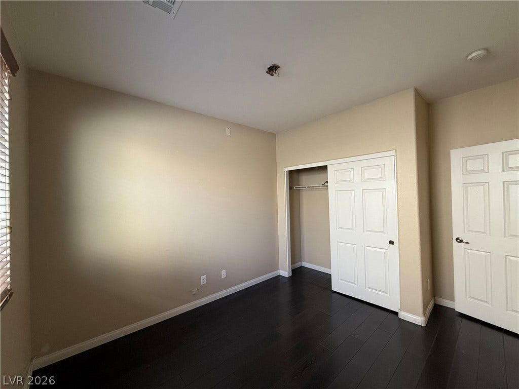 4327 Oasis Hill Avenue, North Las Vegas, NV 89085 Rich dark wood flooring anchors this versatile bedroom space.