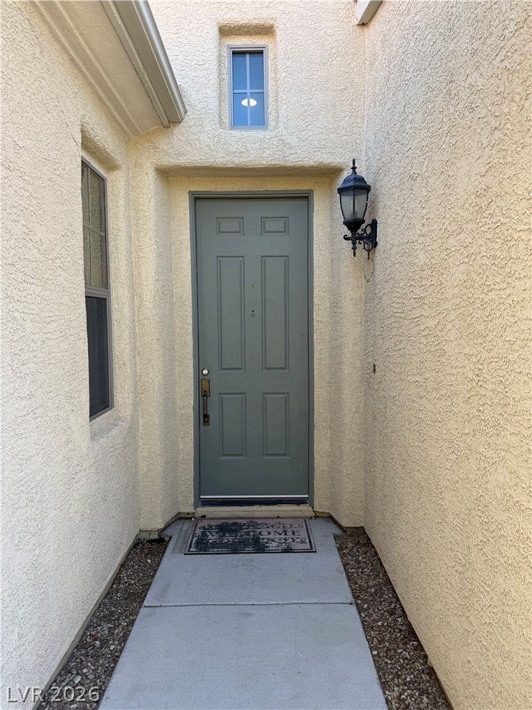 4327 Oasis Hill Avenue, North Las Vegas, NV 89085 An inviting recessed entryway features textured stucco walls and a clean concrete pathway.