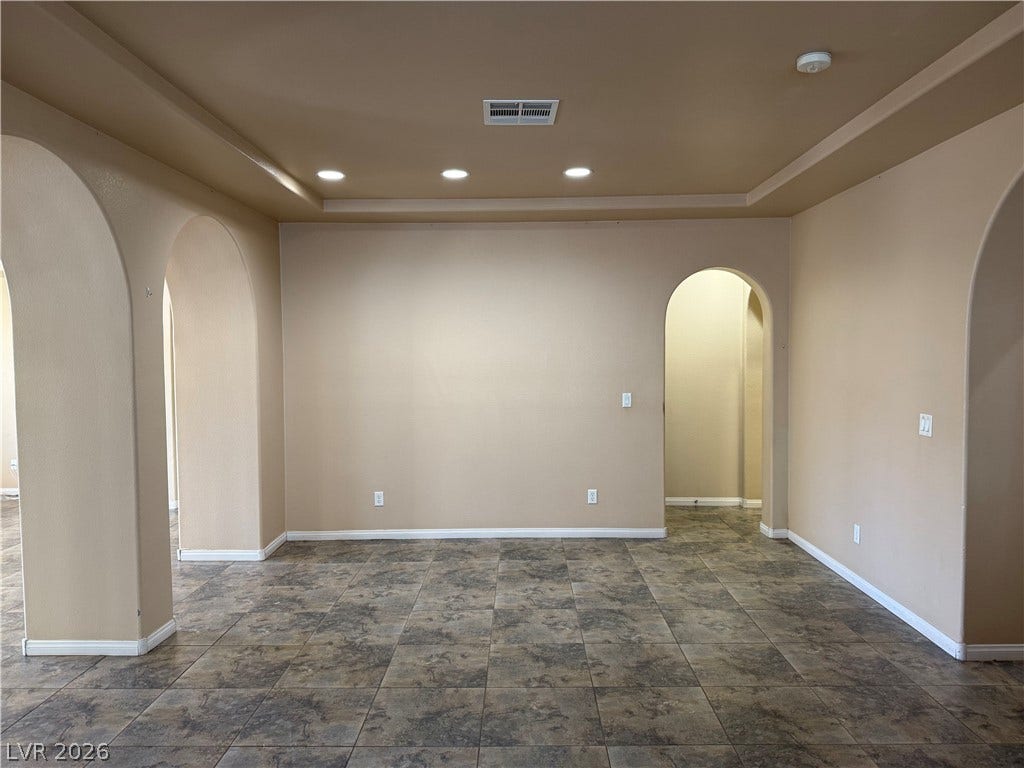 4327 Oasis Hill Avenue, North Las Vegas, NV 89085 Classic arched doorways frame an open living area detailed with recessed lighting and tile flooring.