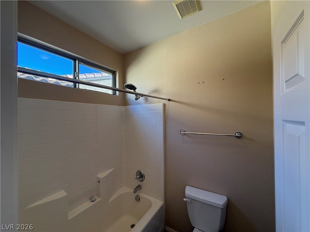 4327 Oasis Hill Avenue, North Las Vegas, NV 89085 A high window brings natural light into this bathroom featuring a tiled tub surround.