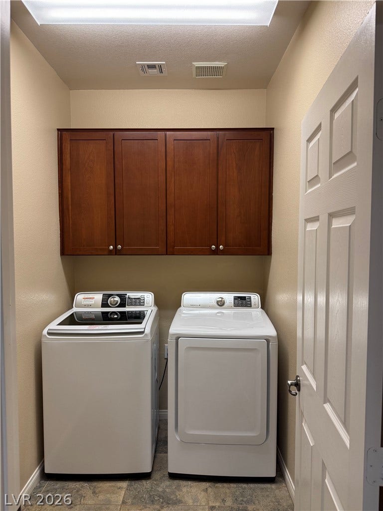 4327 Oasis Hill Avenue, North Las Vegas, NV 89085 Rich wood cabinetry adds convenient storage space above the laundry appliances.