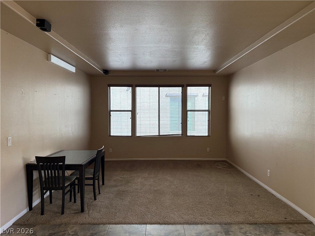 4327 Oasis Hill Avenue, North Las Vegas, NV 89085 A spacious room features plush carpeting and a large window providing natural light.