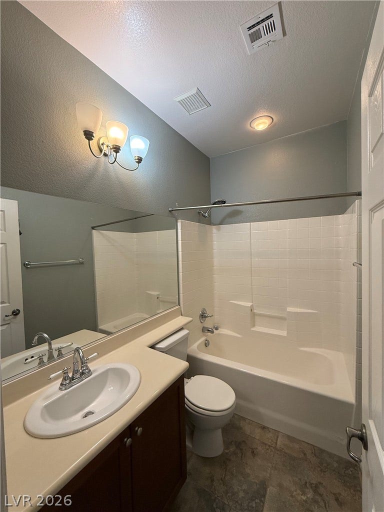4327 Oasis Hill Avenue, North Las Vegas, NV 89085 A classic vanity pairs with a tiled tub shower combination in this functional bathroom.