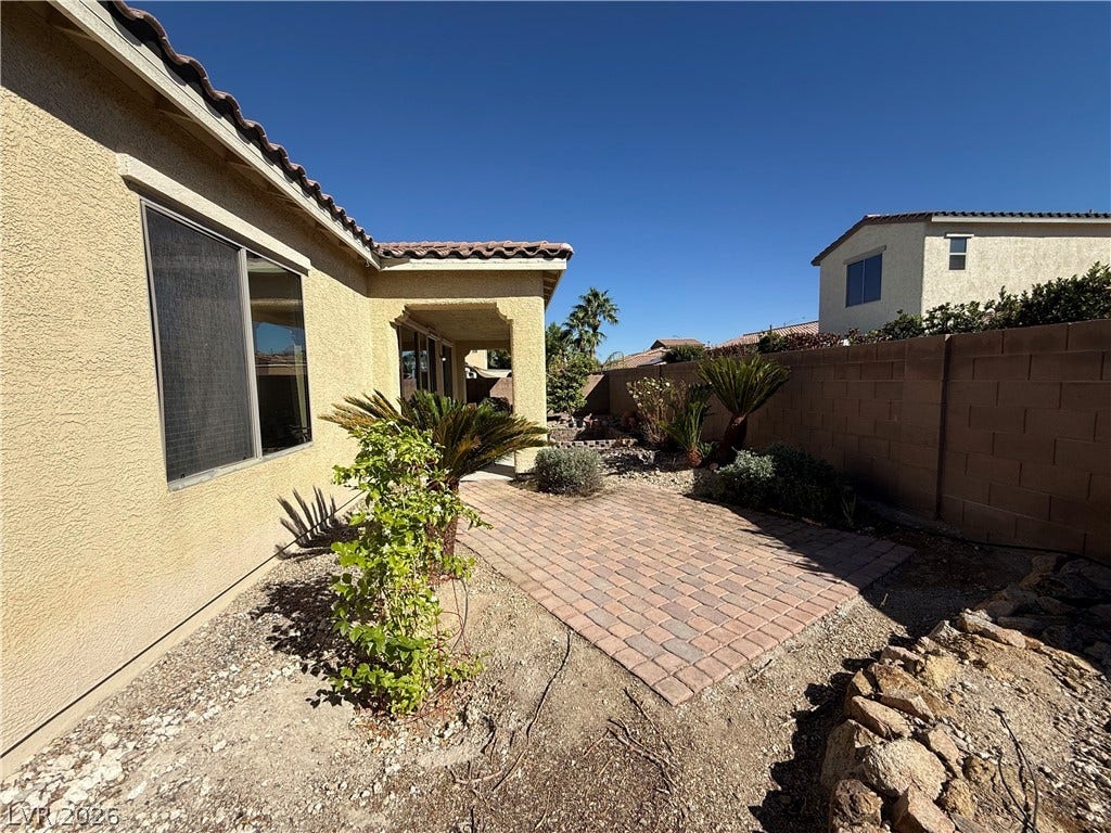 4327 Oasis Hill Avenue, North Las Vegas, NV 89085 Brick paving creates an inviting outdoor patio space adjacent to the stucco exterior.