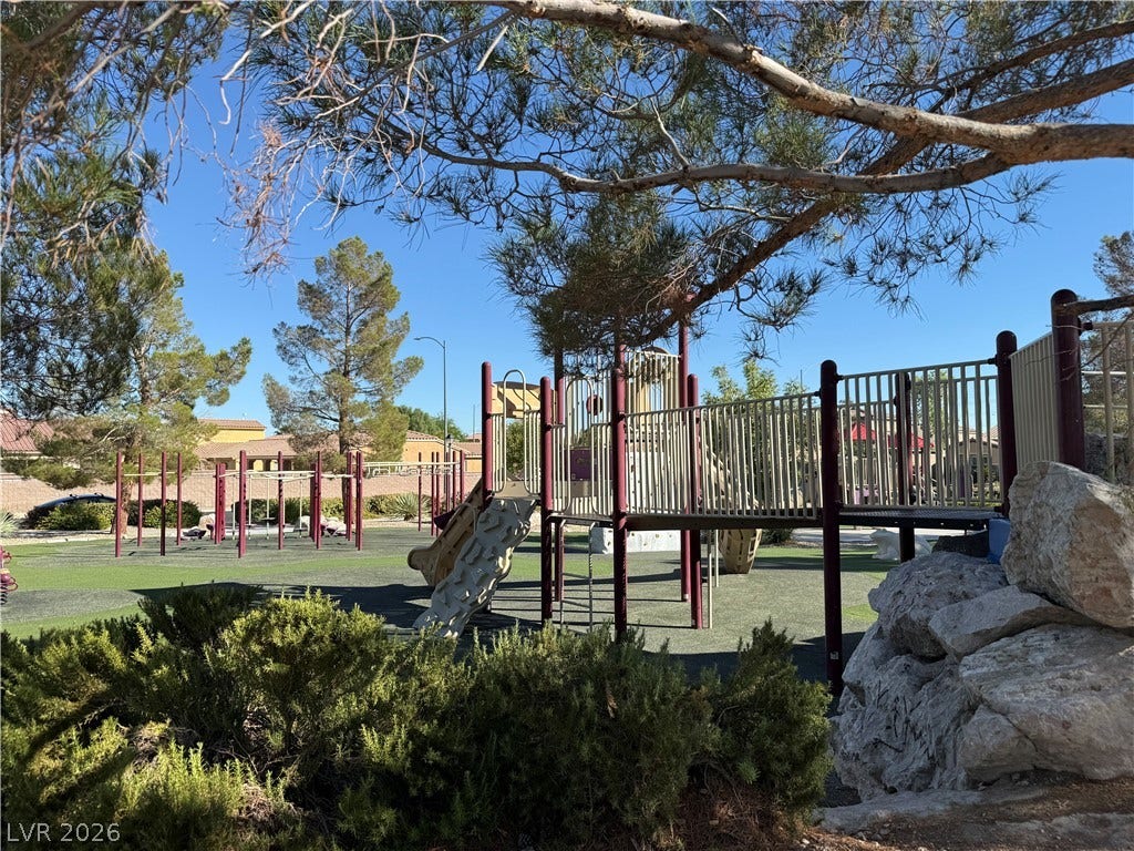 4327 Oasis Hill Avenue, North Las Vegas, NV 89085 Mature trees frame a neighborhood play structure nestled within a sunny park setting.