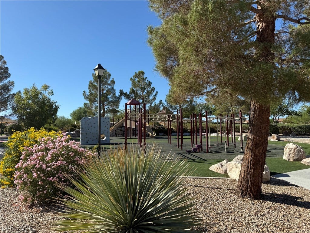 4327 Oasis Hill Avenue, North Las Vegas, NV 89085 Lush mature trees and dessert plantings frame a neighborhood playground under clear blue skies.