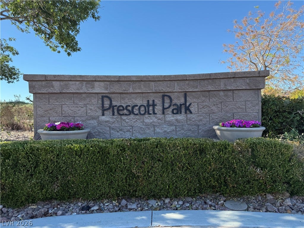 4327 Oasis Hill Avenue, North Las Vegas, NV 89085 Manicured hedges frame a stone monument sign beneath clear blue skies.
