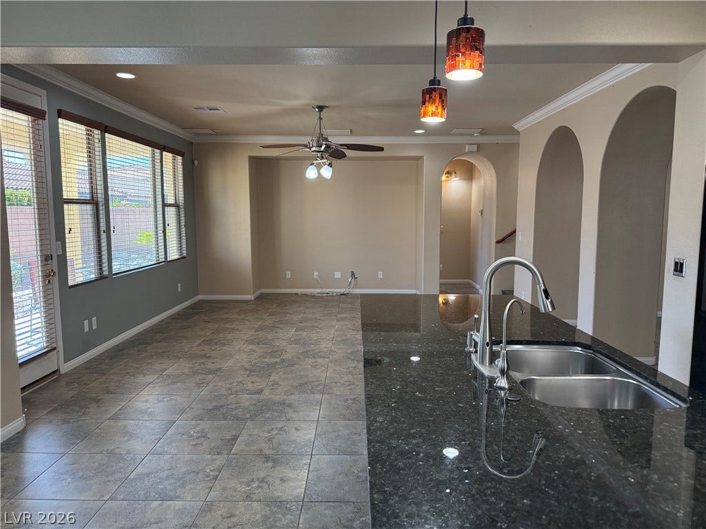 4327 Oasis Hill Avenue, North Las Vegas, NV 89085 Arched doorways and polished stone counters elevate this airy kitchen and adjacent living space.