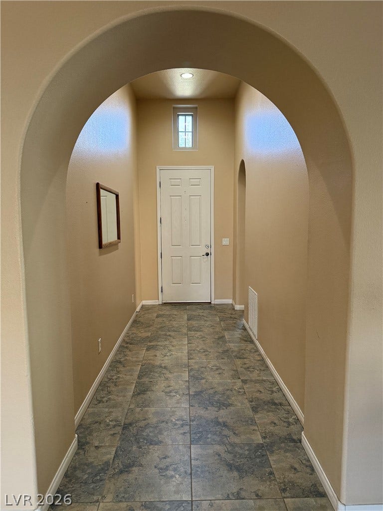 4327 Oasis Hill Avenue, North Las Vegas, NV 89085 An arched opening welcomes guests into a high-ceilinged entry defined by tiled flooring.