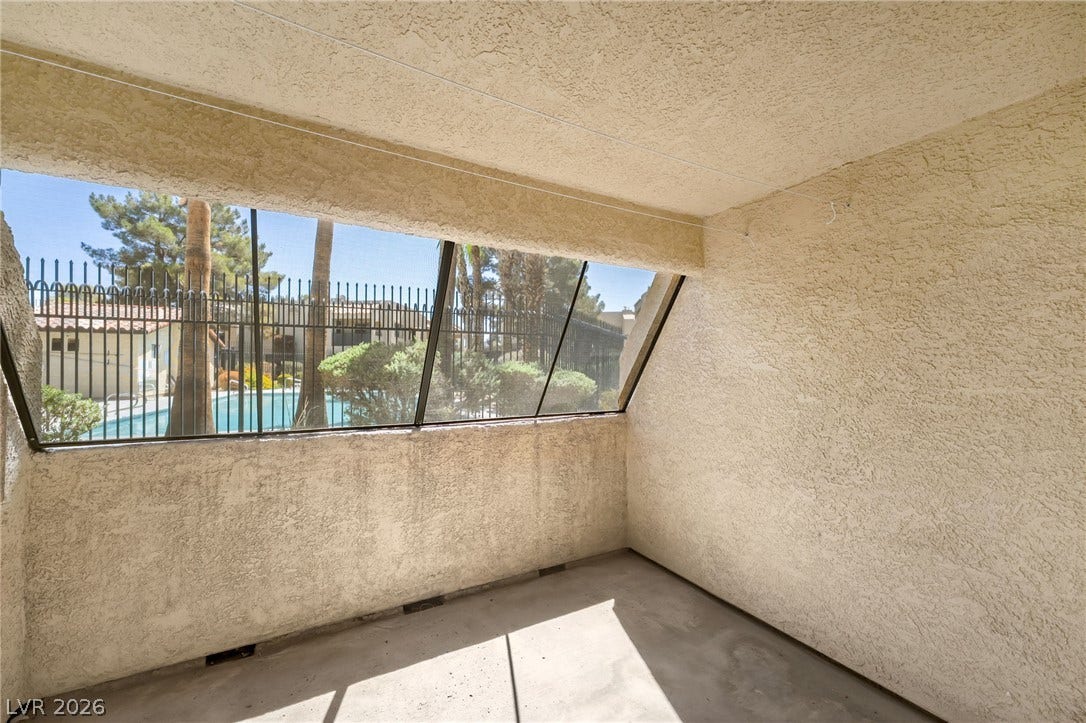601 Cabrillo Circle, #431, Henderson, NV 89015 Shaded concrete patio overlooks a serene community pool area through wide windows.