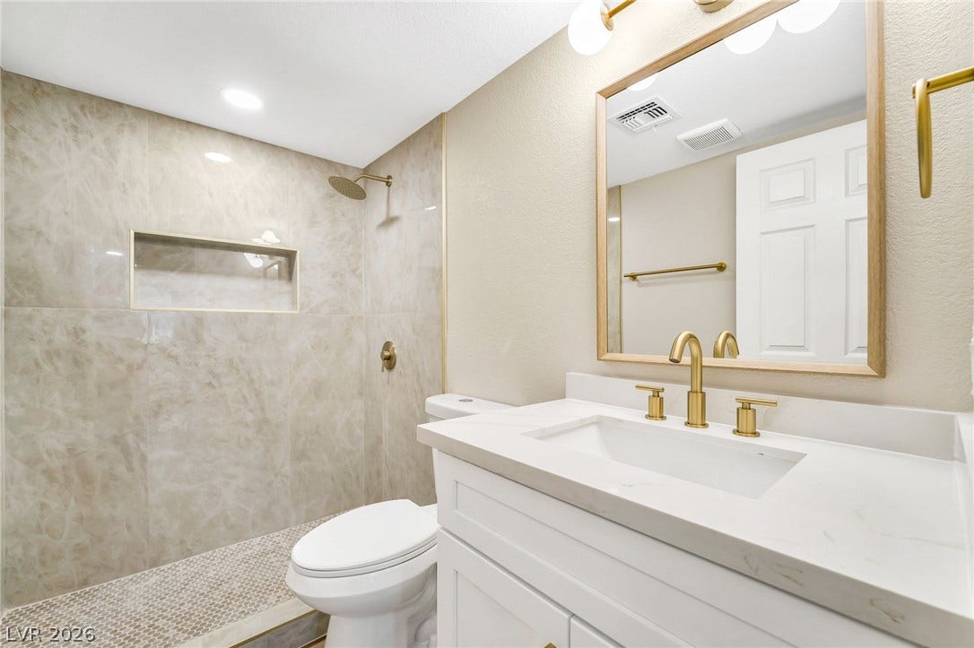601 Cabrillo Circle, #431, Henderson, NV 89015 A modern bathroom features a tiled walk-in shower alongside a single vanity with gold hardware.