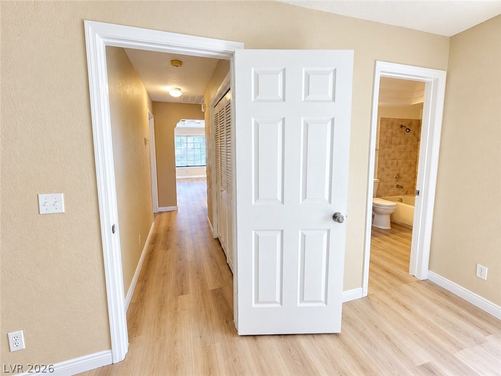 1417 Santa Margarita Street, #G, Las Vegas, NV 89146 Gleaming wood-look floors connect the hallway, bedroom, and nearby bathroom seamlessly.