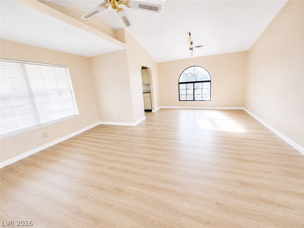 1417 Santa Margarita Street, #G, Las Vegas, NV 89146 Warm vinyl flooring and vaulted ceilings define this airy living space with arched window detailing.