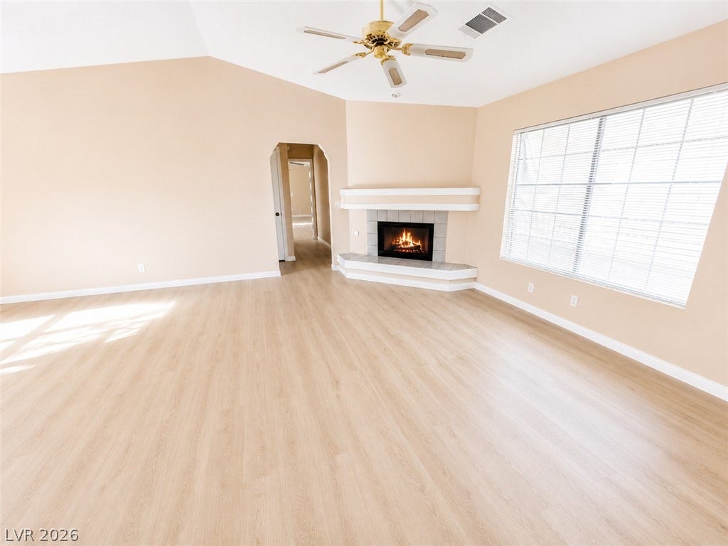 1417 Santa Margarita Street, #G, Las Vegas, NV 89146 Vaulted ceilings and a corner fireplace highlight this airy living room with new vinyl inspired flooring.
