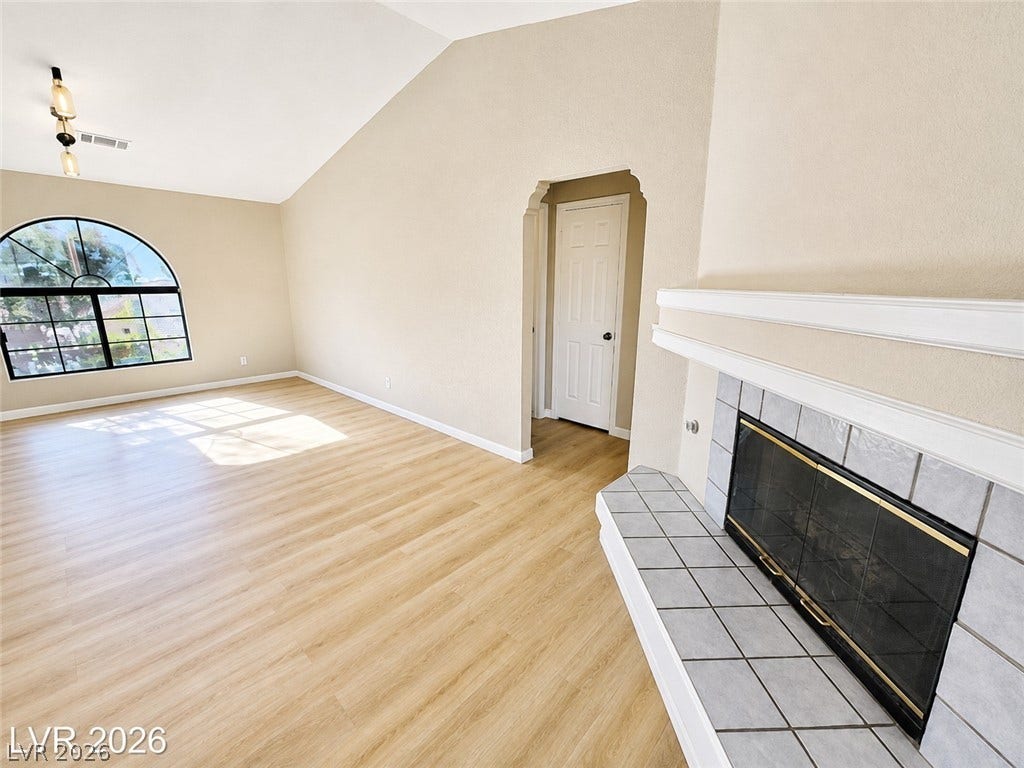 1417 Santa Margarita Street, #G, Las Vegas, NV 89146 An arched window and tiled gas fireplace anchor this airy room beneath a vaulted ceiling.
