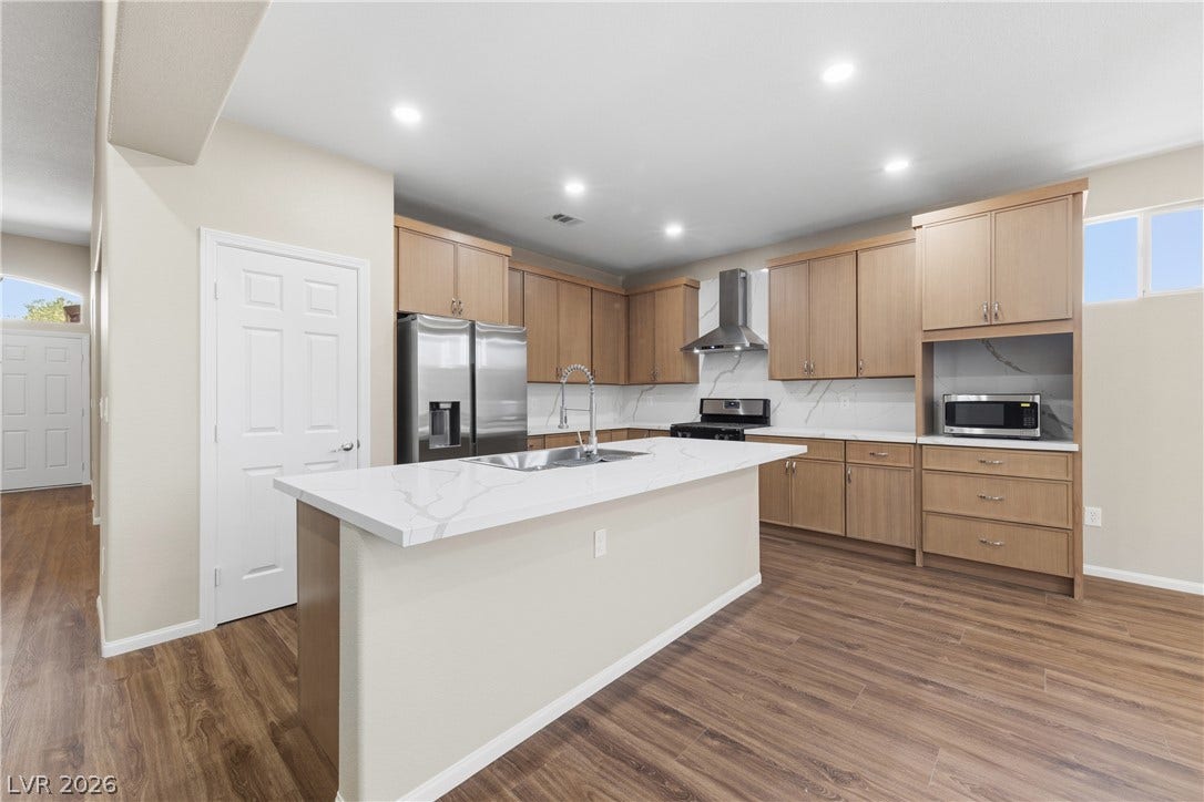 9613 Cherry Canyon Avenue, Las Vegas, NV 89129 Gleaming stone countertops and warm wood floors define this modern, functional culinary space.