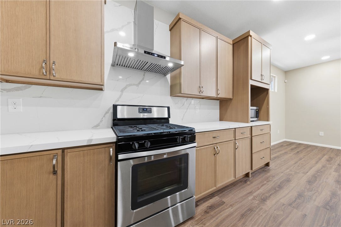 9613 Cherry Canyon Avenue, Las Vegas, NV 89129 Warm wood cabinetry pairs with elegant stone countertops in this modern kitchen design.