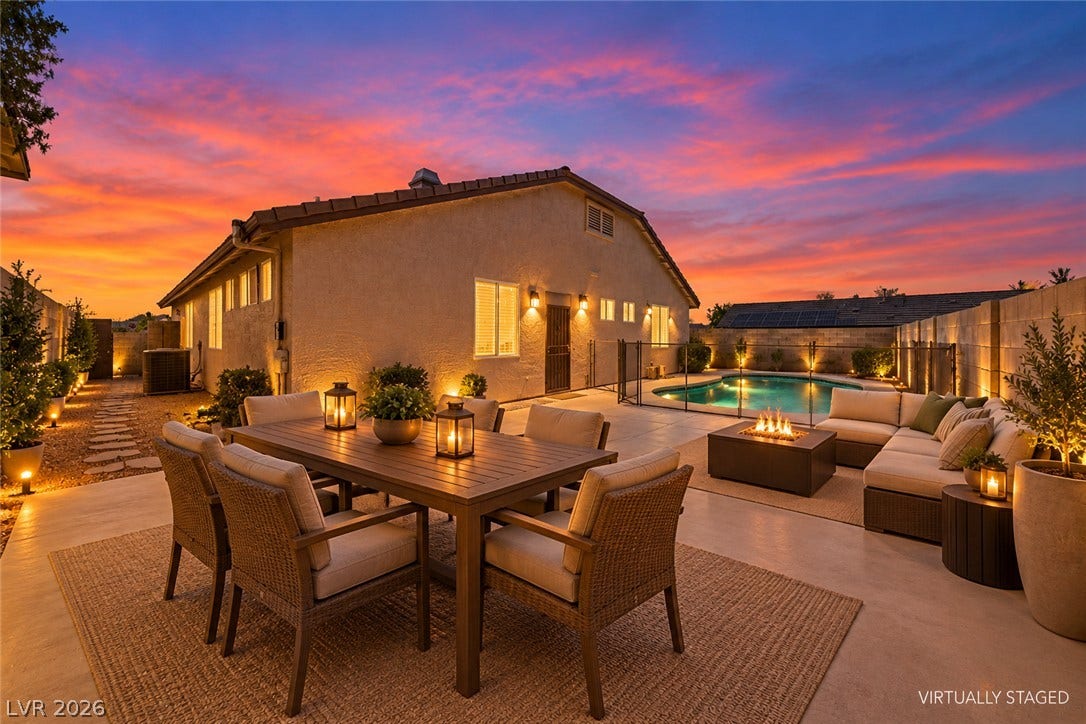 9613 Cherry Canyon Avenue, Las Vegas, NV 89129 An inviting backyard patio overlooks a sparkling swimming pool under vibrant twilight skies.