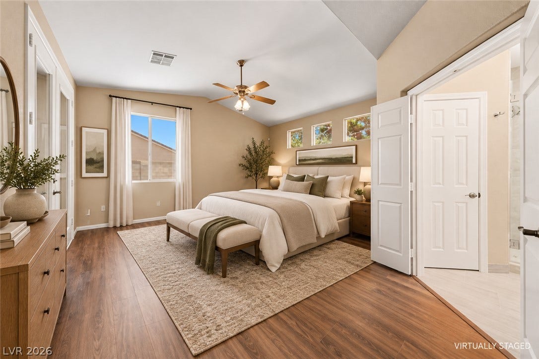 9613 Cherry Canyon Avenue, Las Vegas, NV 89129 High vaulted ceilings and rich wood floors anchor this comfortable primary bedroom suite.