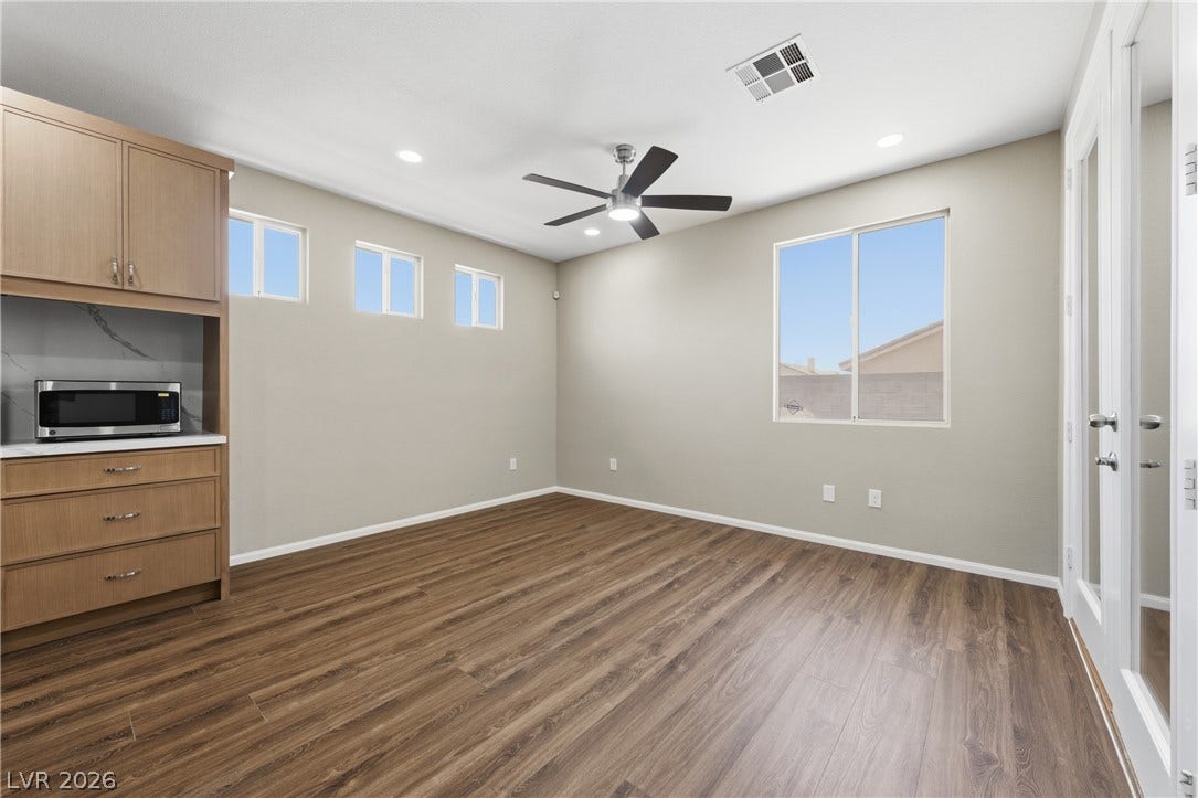 9613 Cherry Canyon Avenue, Las Vegas, NV 89129 Rich wood-look flooring and built-in cabinetry define this versatile living space.