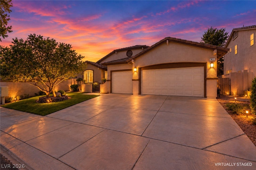 9613 Cherry Canyon Avenue, Las Vegas, NV 89129 An expansive concrete driveway leads to a modern three-car garage under elegant exterior lighting.