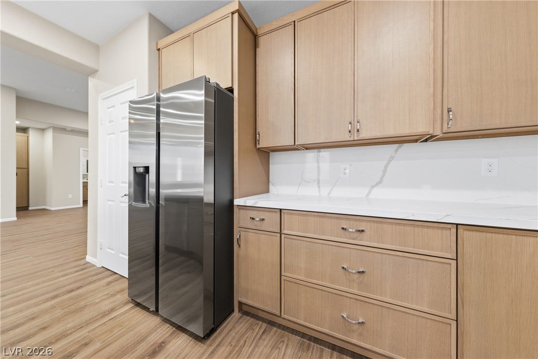 9613 Cherry Canyon Avenue, Las Vegas, NV 89129 Streamlined cabinetry and sleek stone countertops define this modern culinary workspace.