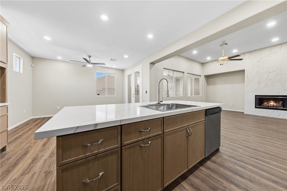 9613 Cherry Canyon Avenue, Las Vegas, NV 89129 An open-concept layout connects the kitchen island to the fireplace-centered living area.