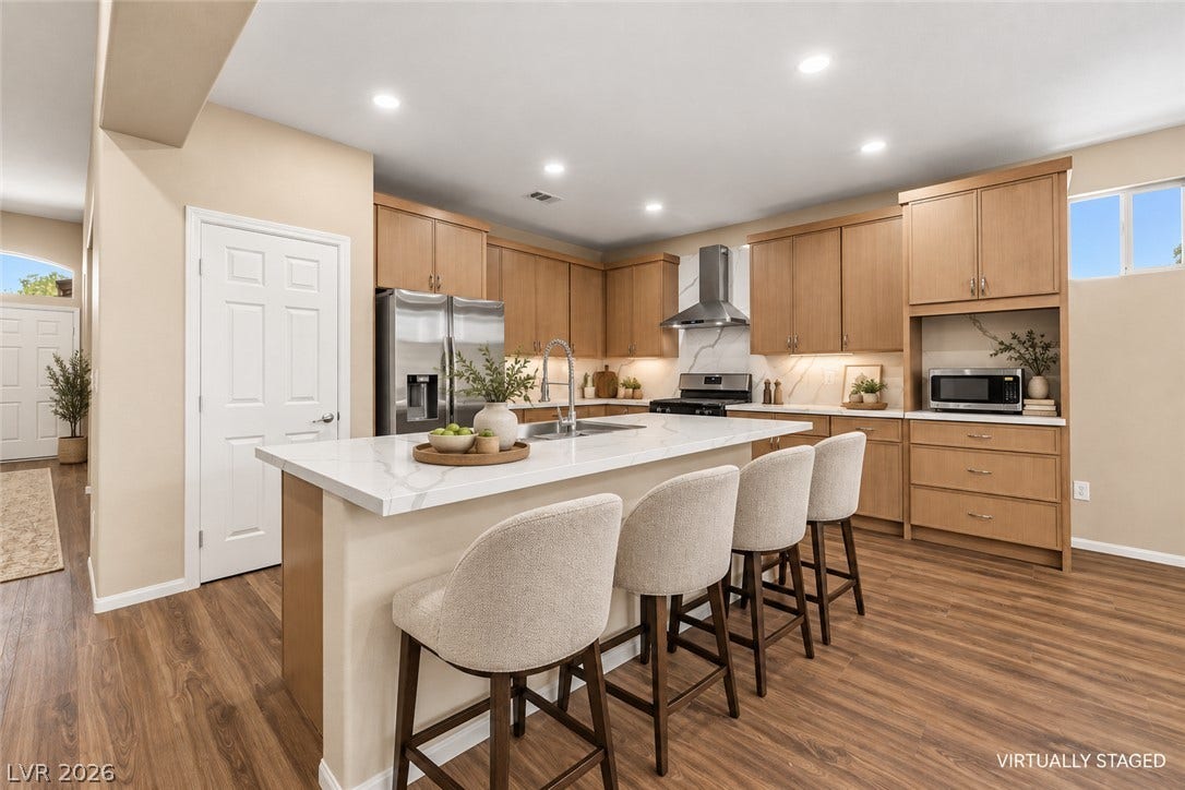 9613 Cherry Canyon Avenue, Las Vegas, NV 89129 Warm wood cabinetry and a central island with stone counters anchor this kitchen space.