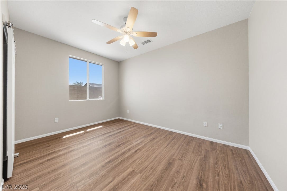 9613 Cherry Canyon Avenue, Las Vegas, NV 89129 Smooth wood-style flooring and natural light define this versatile bedroom space.