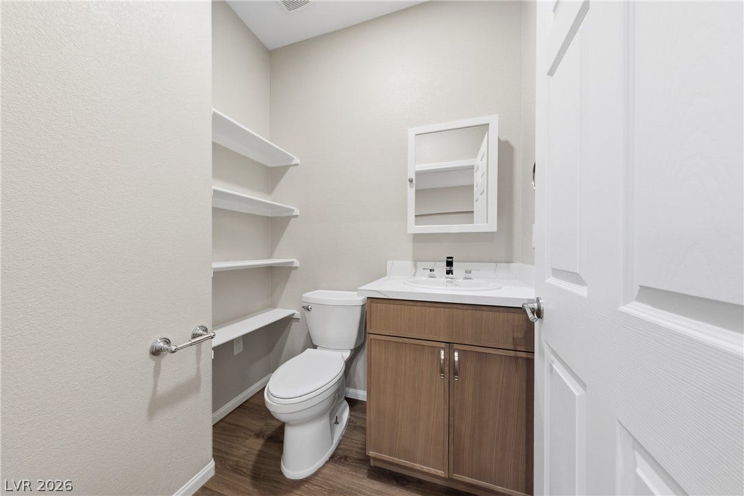 9613 Cherry Canyon Avenue, Las Vegas, NV 89129 A compact powder room utilizes vertical space with open shelving alongside the vanity.