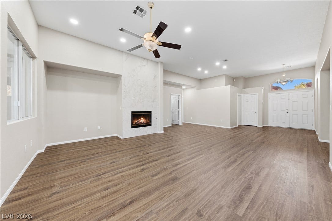 9613 Cherry Canyon Avenue, Las Vegas, NV 89129 An open floorplan centers around a marble-clad fireplace and handsome wood-look flooring.