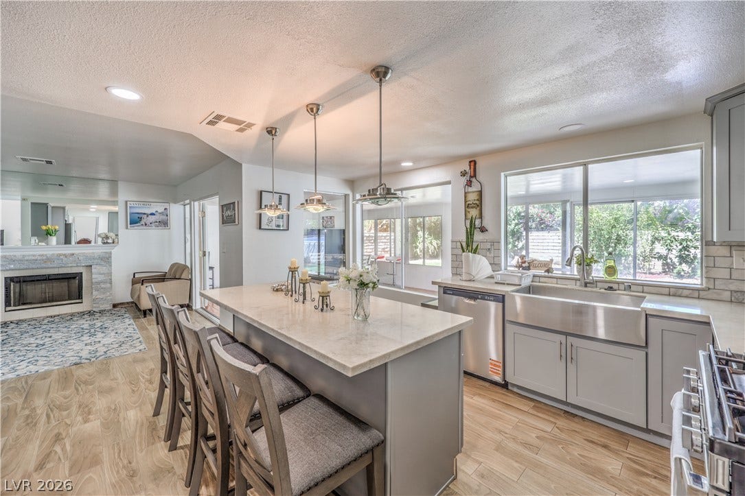 An open kitchen highlights durable stone countertops and seamless connection to the living area.