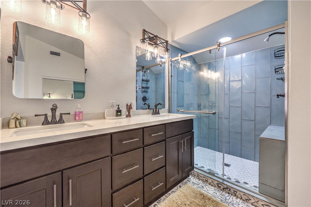 Double vanities and a tiled walk-in shower elevate this updated bathroom design.