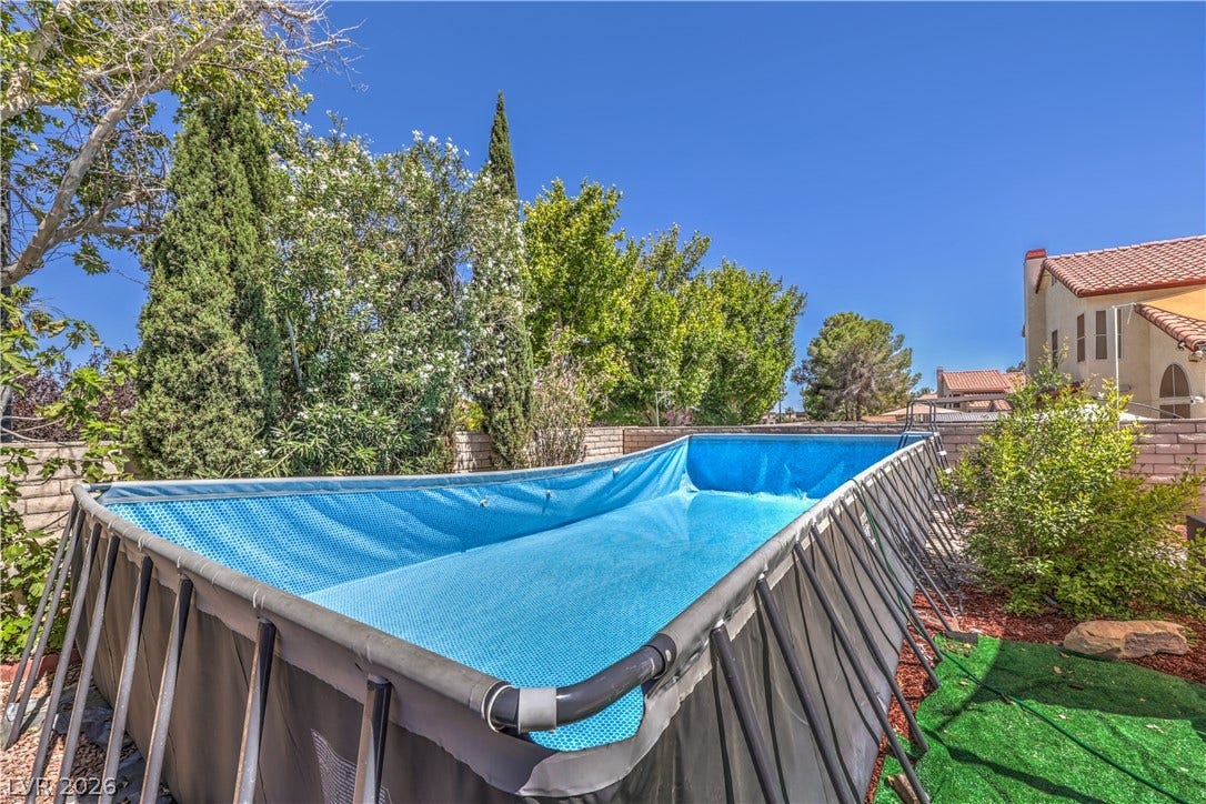 A spacious backyard features a private swimming pool enclosed by secure block walls.