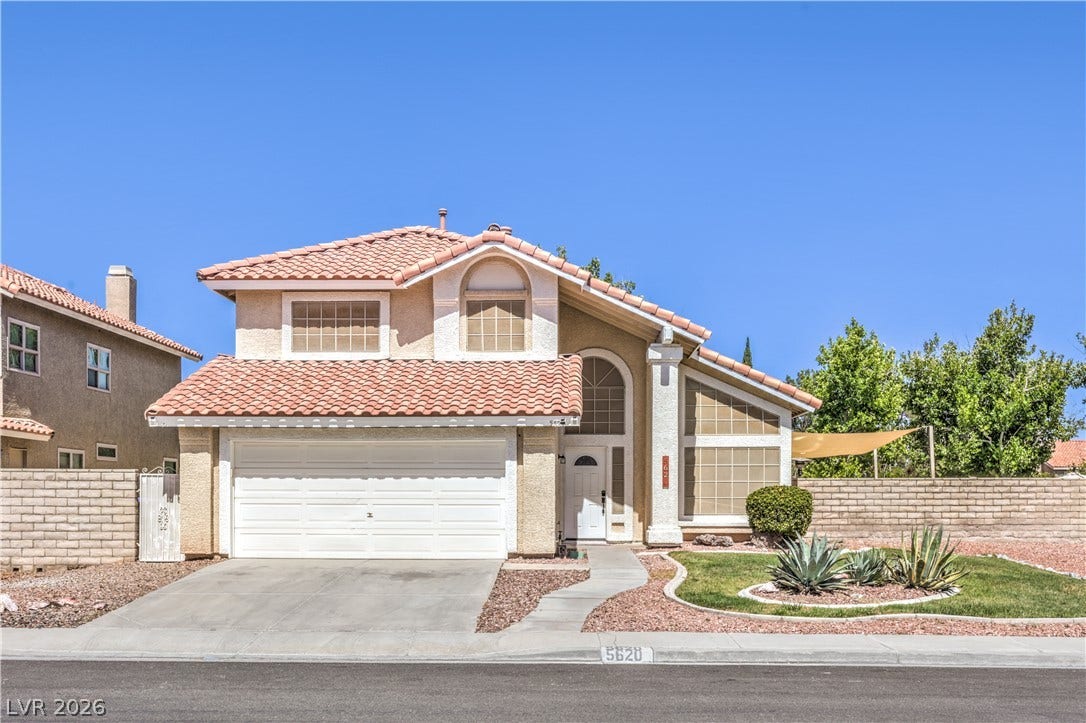 A classic Spanish tile roof and desert-inspired landscaping frame this two-story exterior facade.