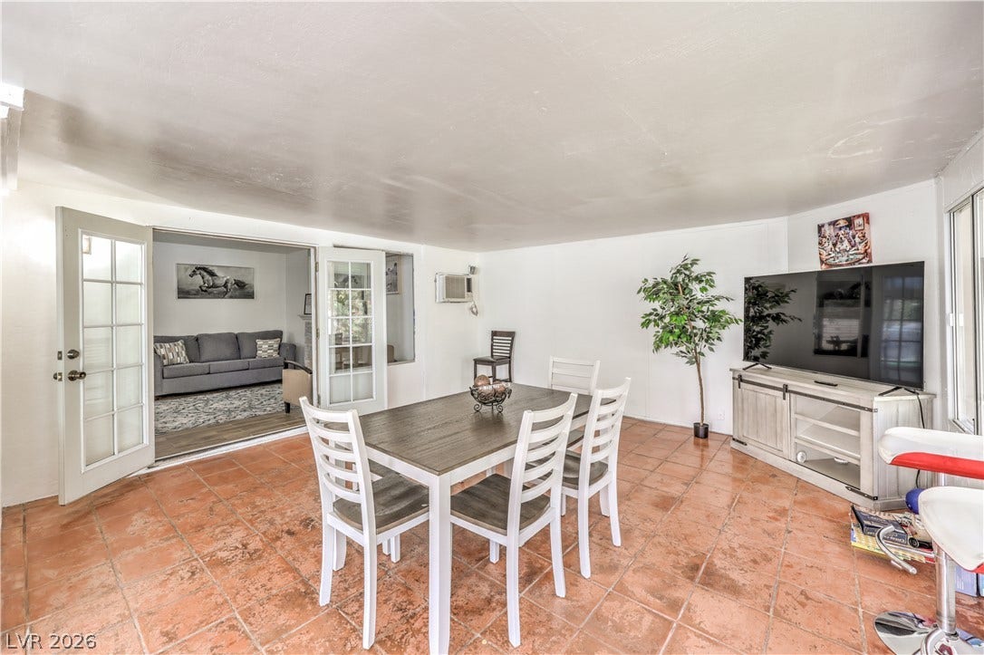 French doors connect this sun-drenched dining space seamlessly to the adjoining living room.