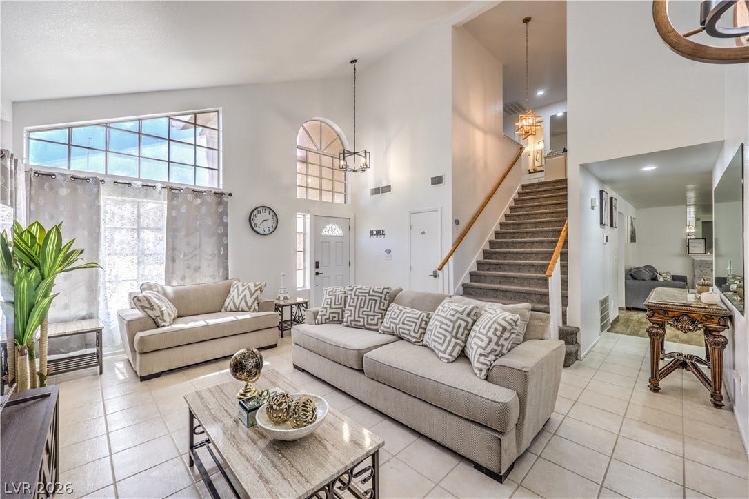 Soaring vaulted ceilings and tile flooring create an airy ambience in this central living area.