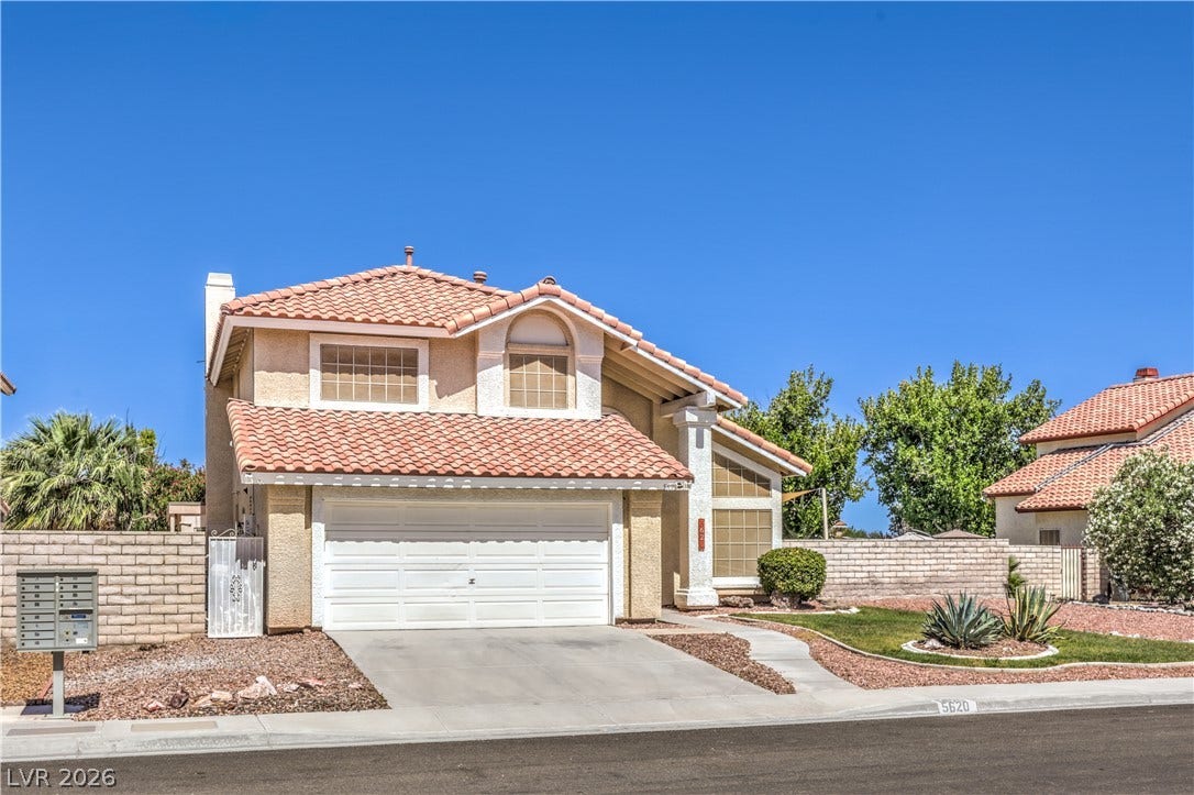 Spanish tile roofing and a concrete driveway define this classic suburban exterior.