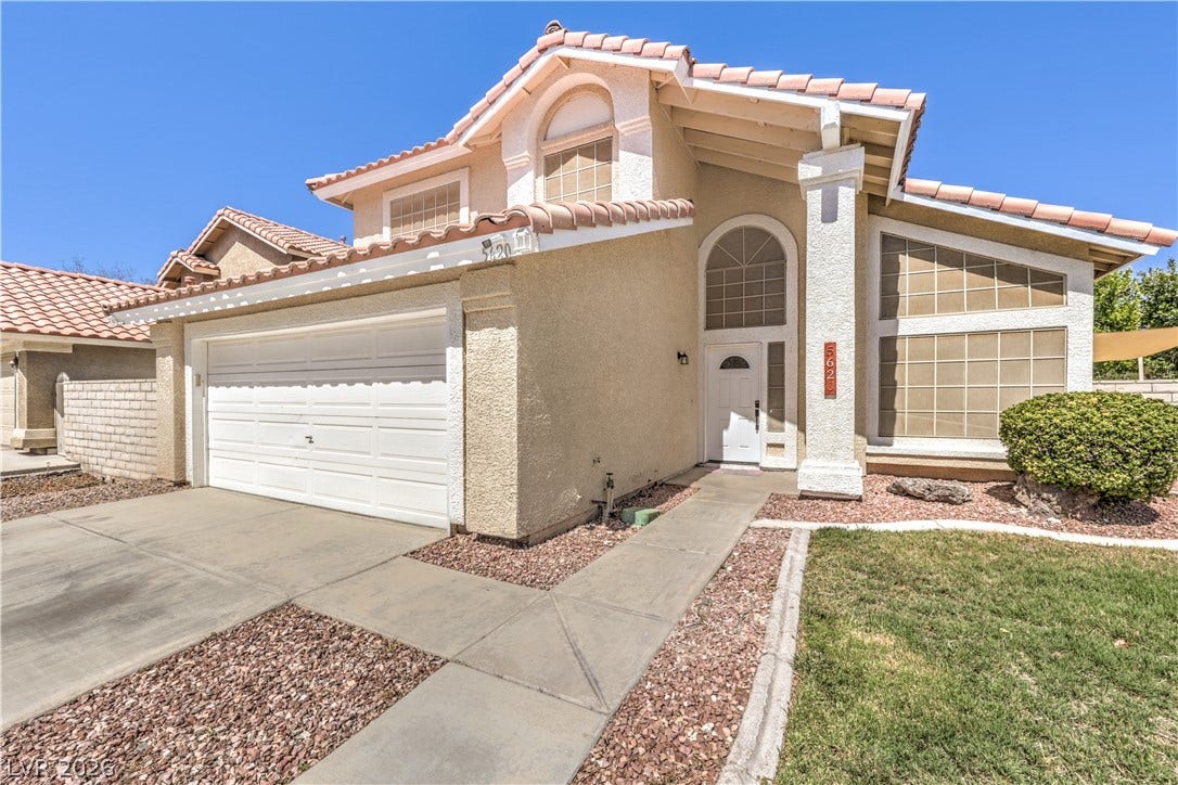 A stucco exterior and Spanish tile roof define this multi-level home with an attached garage.