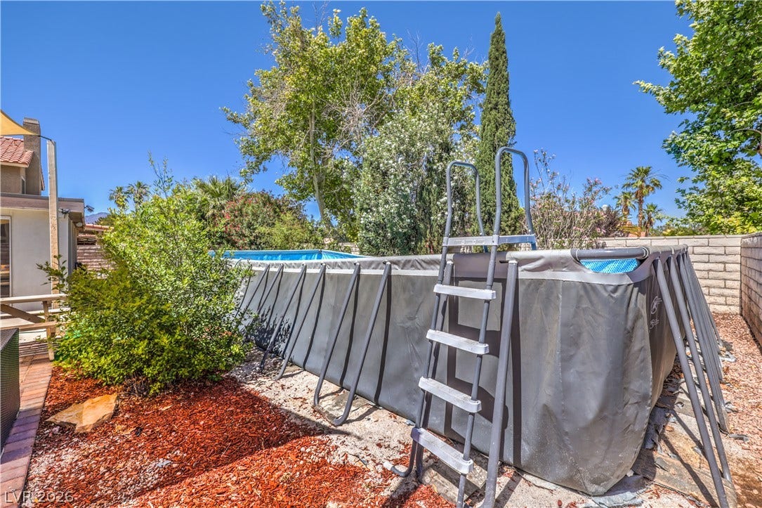 Mature trees frame the backyard recreation area with its practical above ground pool.